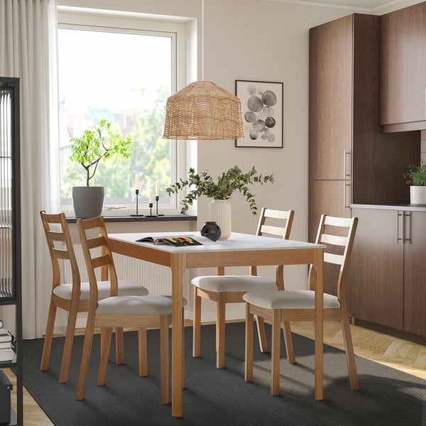 Modern oak TRÖDEN dining set with ceramic-top table and four chairs in a bright, spacious room.