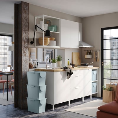 Modern kitchen with white cabinets and TRÖSKNING bins. Recycled plastic, fits under cabinets.