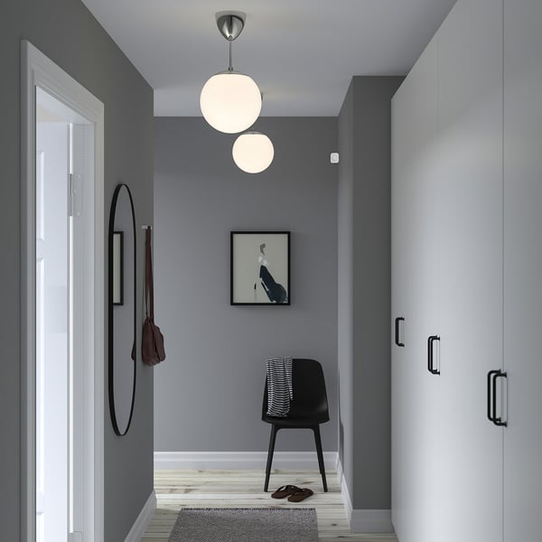 A modern grey hallway featuring black chair, mirror, and VALLHORN sensor.