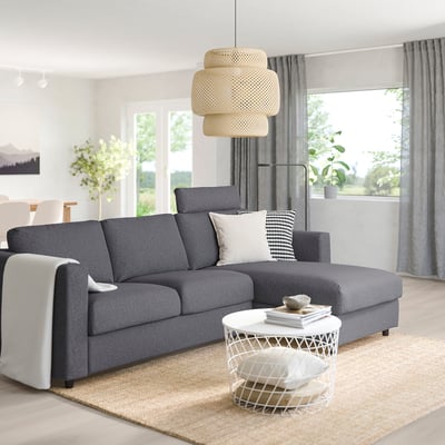Modern grey VIMLE sectional sofa with white coffee table, large window, and unique pendant lamp.