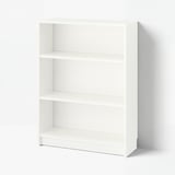 Bela knjižna omara BILLY s tremi praznimi policami. Preprosta je, vsestranska in izdelana iz iverne plošče ter melaminske folije.