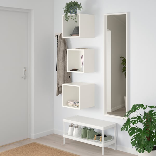 Bele police EKET z dekorjem, rastlina. Klop, ogledalo spodaj, modra stena.