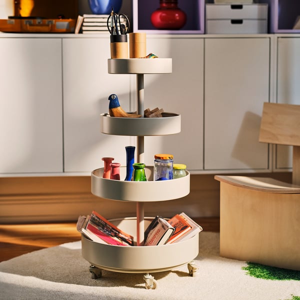 IKEA PS 2026: bež, okrogel, večnivojski kovinski organizatorski voziček. Večja od povprečja, lepo ustreza različnim kobilom.