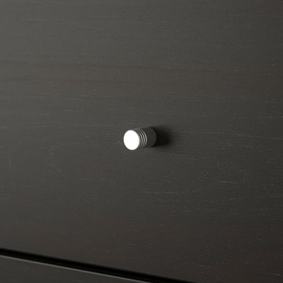 Bližnji posnetek elegantnega, črnega ročaja predala KALLAX; sodoben in minimalističen dizajn.
