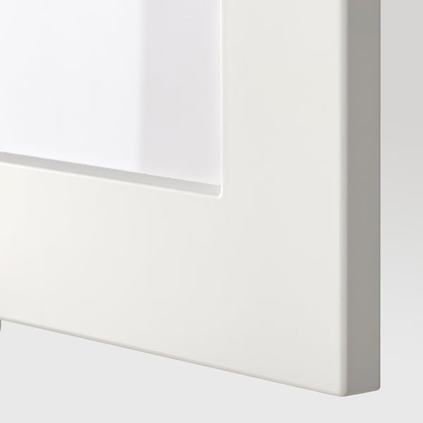 Bližnji posnetek ostrega belega vogala omare, ki prikazuje eleganten, sodoben dizajn in natančno izdelavo.
