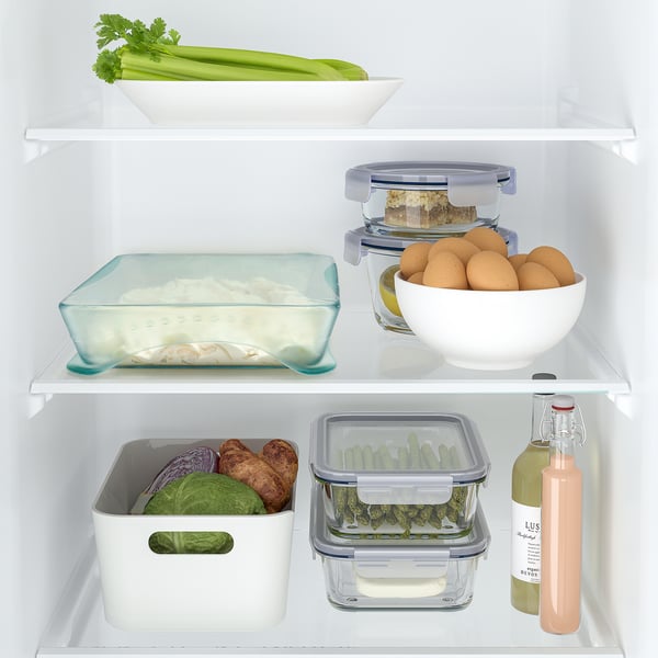 Dobro organizirana vsebina hladilnika s svežim sadjem, zelenjavo in posodami za hrano.