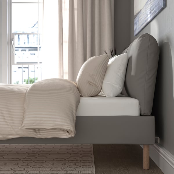 Postelja s poševnim vzglavjem in blazinami, idealna za branje ali sprostitev. Pokrov je odstranljiv za enostavno čiščenje.