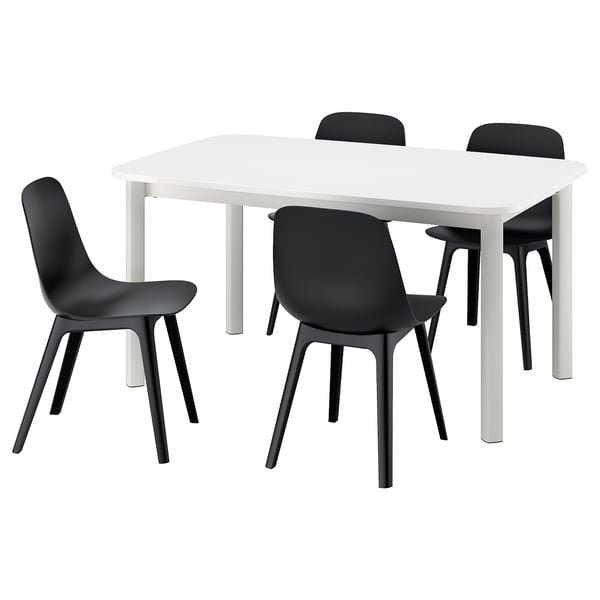Bela raztegljiva jedilna miza IKEA STRANDTORP s štirimi črnimi stoli. Stoli imajo ukrivljene sedeže in črne noge.