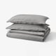 Grey bedding set: two pillows, folded flat sheet, all in soft washed cotton.