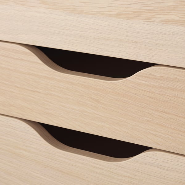 Clean, minimalist light wood drawers with smooth, overhand cut handles.