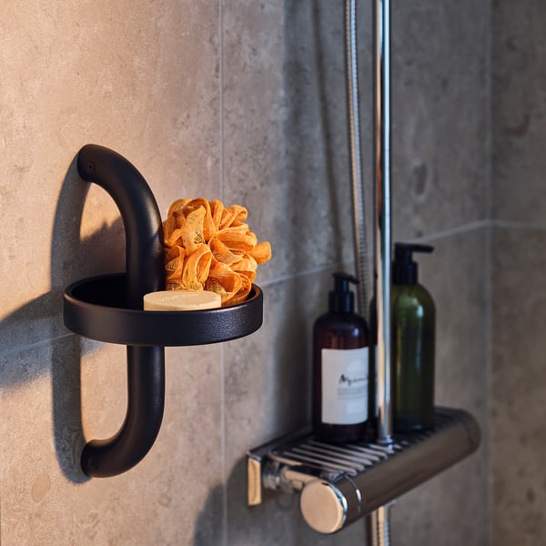 Black shower handle shelf set. Includes orange bath sponge and two soap dispensers mounted on grey tiled wall.