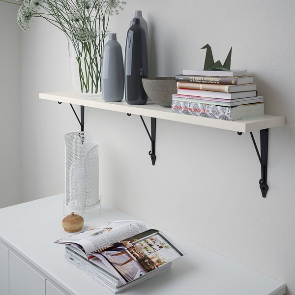 Realistic a white wall shelf with two vases, a stack of books, and a cylinder light.