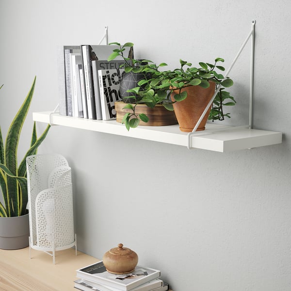 White shelf holding books, plant, decor against grey wall, supports 10 kg