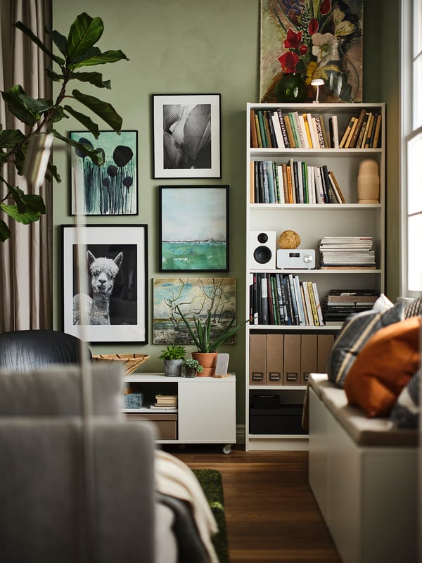 Modern living room with green walls, BILLY bookcases filled with books and decor.