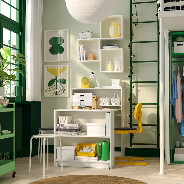 Home office: BILLY shelves, yellow accents, plant, wooden floor, green wall, ladder.