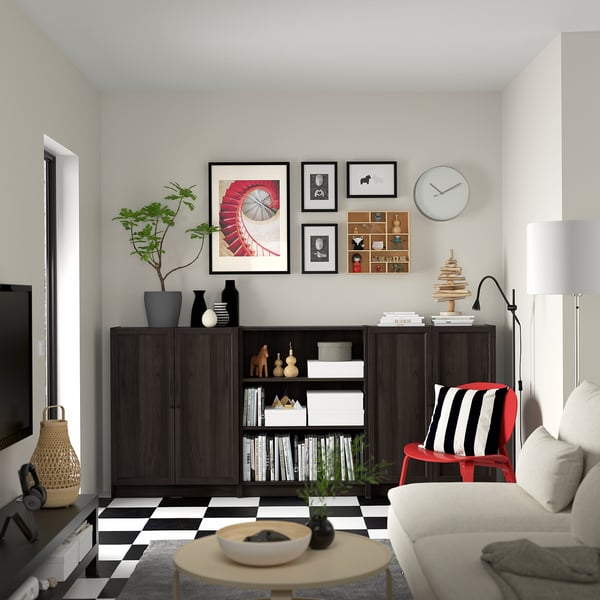 Modern living room with dark wood BILLY bookcase, colourful chair, and gallery wall.