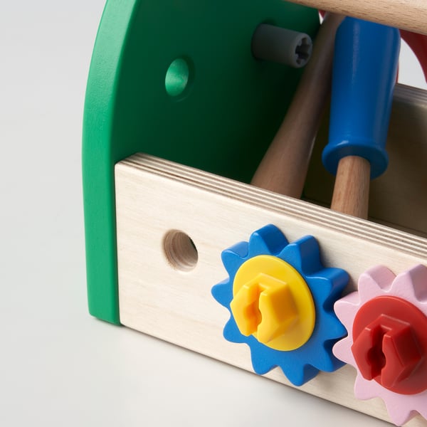 Wooden toy box with green side, colourful gears, blue tool. Quality wooden craftsmanship, bright colours.