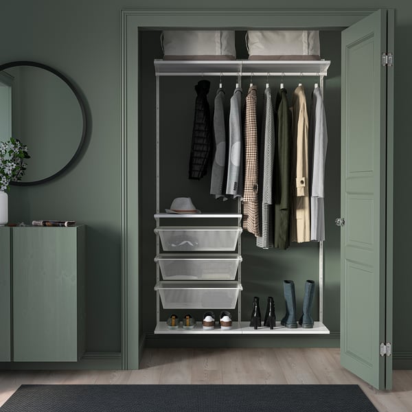 Green walk-in closet with wood floors, BOAXEL storage, mirror, & flowers.