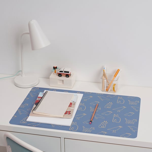 Desk setup with BÖNSYRSA blue mat, notebook, pencils, lamp, toy car. Mat sized for drawing, made of recycled polyester, rubber base.