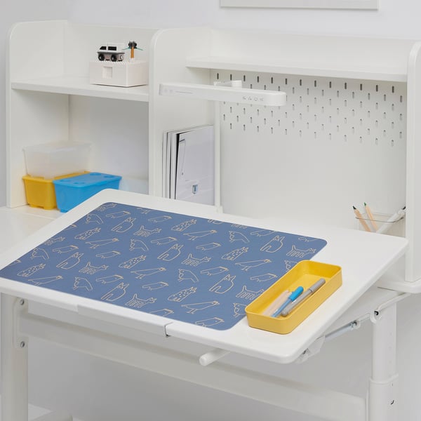 Kids desk with blue art pad, yellow bins, and storage shelves.