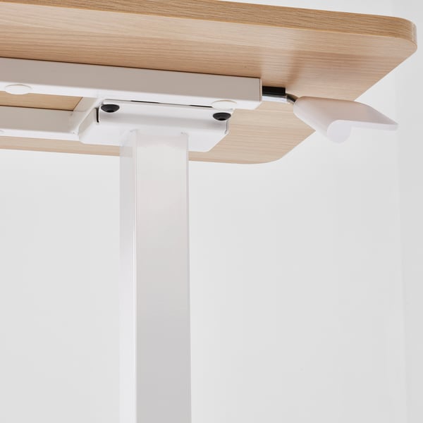 Close-up of height-adjustable table mechanism with wooden top and metal frame.