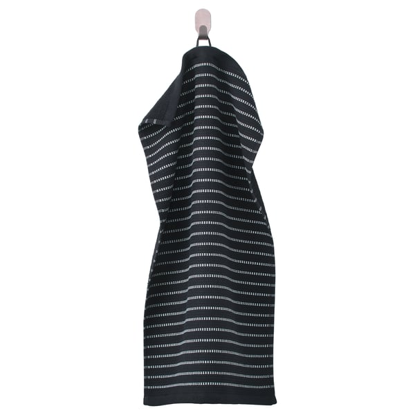 A black BROKGINST towel with a white waffle pattern, hung up. Made of 100% cotton, featuring terry and waffle textures.