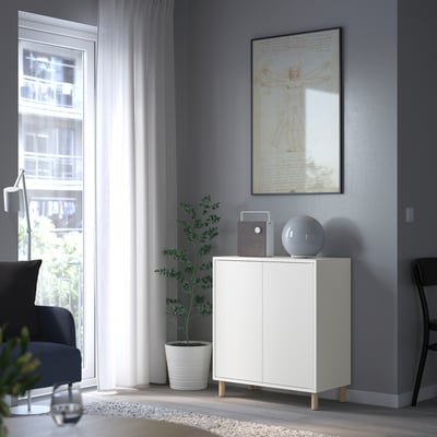 Modern living room with grey walls, large window. EKET storage unit, chair, lamp.