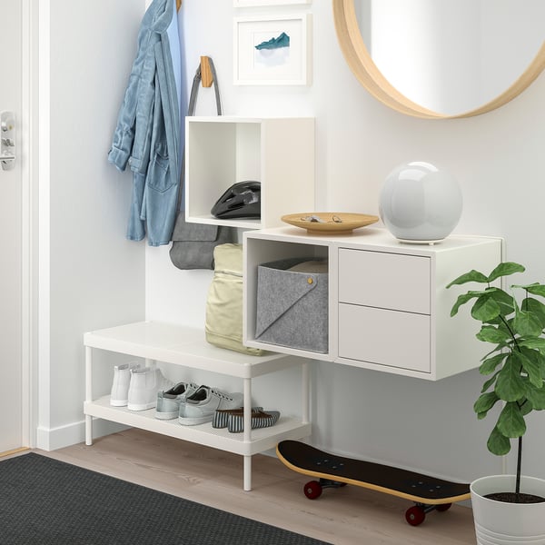 Modern EKET wall cabinet with mixed storage, including drawers, shelf, and coat space. Leans next to a mirror with a skateboard.