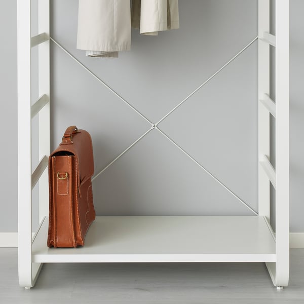 A brown leather bag hangs on a white metal shelf of a modular storage system, showcasing its open and adjustable design.