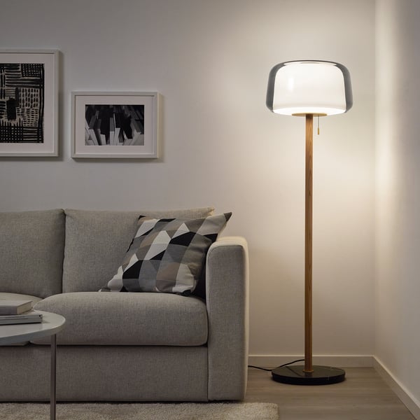 EVEDAL brass & glass lamp with white shade near grey sofa - scandinavian style