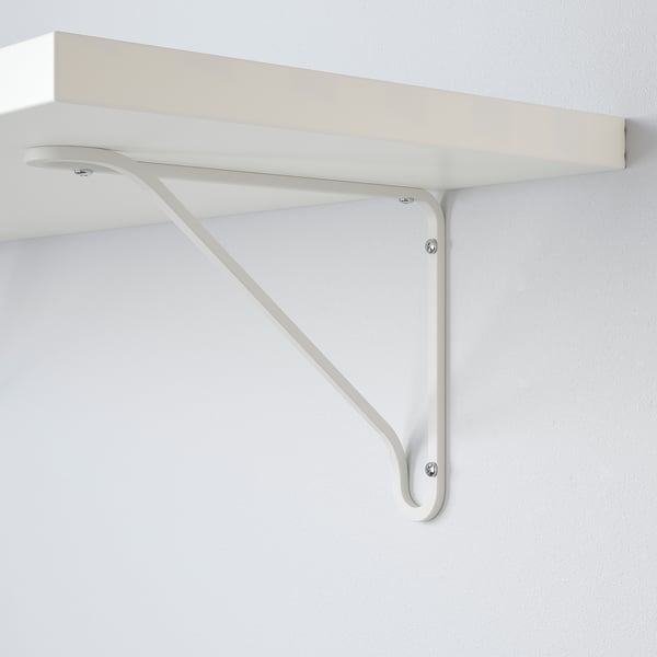 Wall-mounted white metal shelf bracket with slight twist design, securely fastened to white wall.