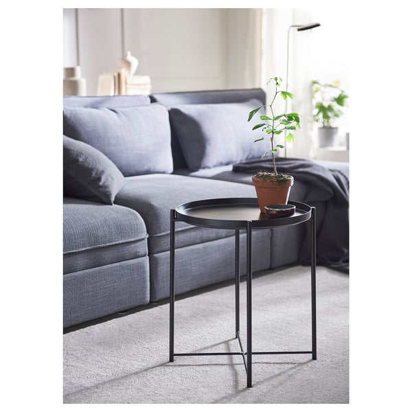 Modern living room with a grey sofa and a small black GLADOM side table holding a potted plant and a small tray.