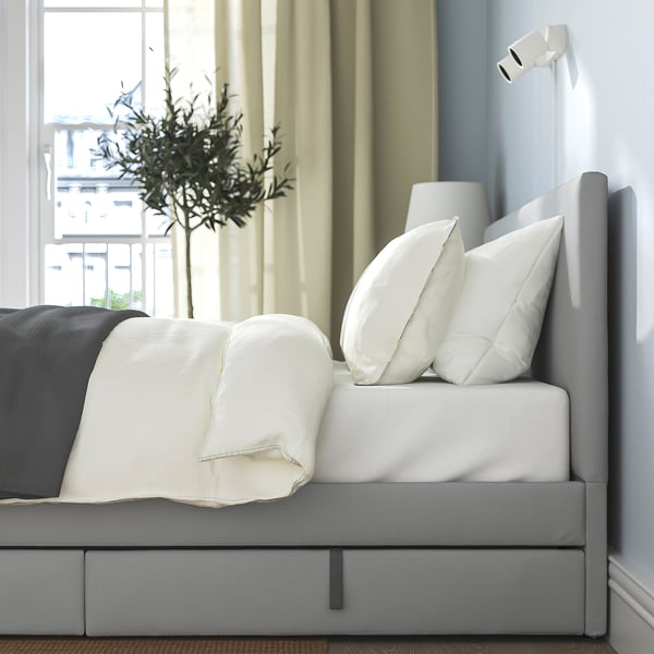 Modern bed with padded headboard 2 storage boxes with castors for easy access, providing both comfort and practical space.