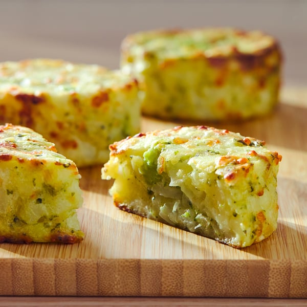 Four cheese and veggie casseroles on wooden board, golden-brown top, rectangular shape.
