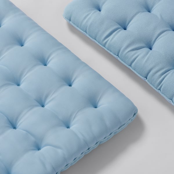 Two light blue chair cushions with a tufted pattern, placed side by side, showcasing their soft and inviting texture.