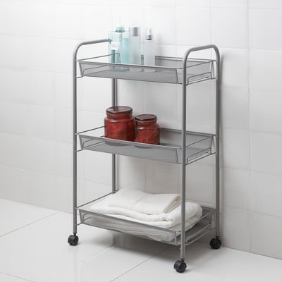 Silver HORNAVAN 3-tier metal bathroom trolley with black wheels holds towels, bottles, and jars; against white tiles.