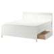 IDANÄS white wooden bed with slatted headboard and wooden drawers.
