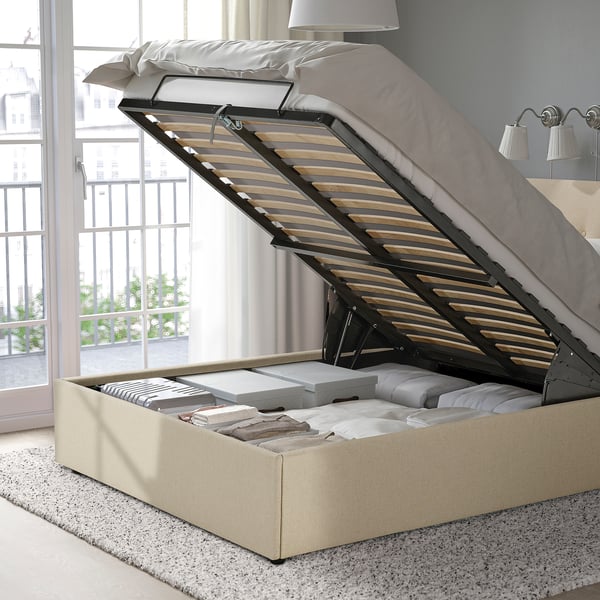 Ottoman bed with open storage under beige upholstered base.