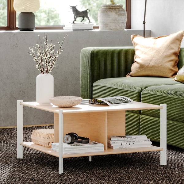 Modern JÄTTESTA coffee table with light wood top, white legs, and storage shelf in living room with green sofa.