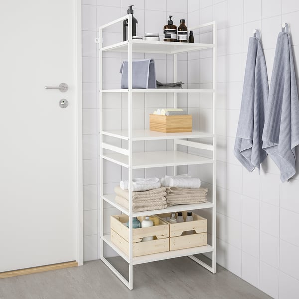 White metal storage unit in corner with shelves and hanging towels.