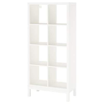 A white KALLAX shelving unit. It has a modern, cube-shaped design with multiple open shelves supported by a metal underframe.