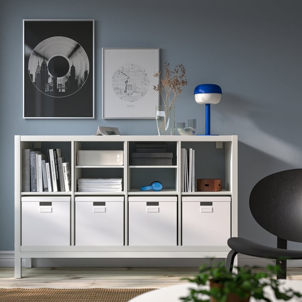 Modern KALLAX shelving unit with storage, books, lamp, and decor.