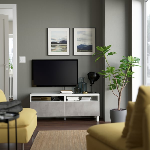 Modern living room with KALLVIKEN tv stand, flat screen, plant, nature prints, and yellow chairs.