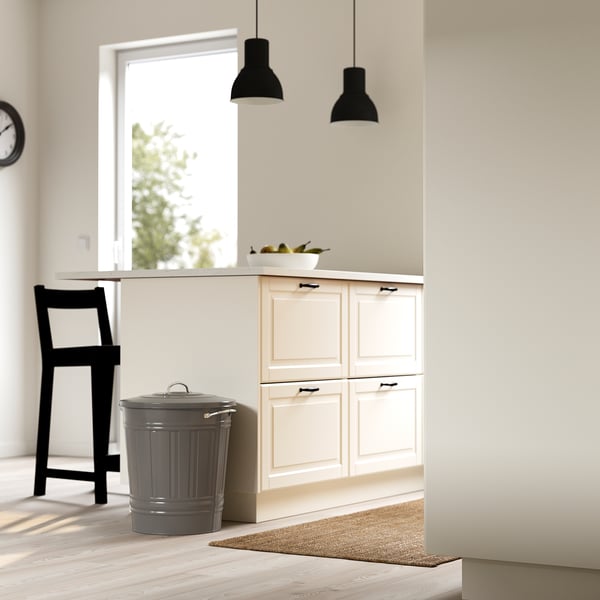 Modern kitchen with white cabinets, a black stool, and a grey KNODD bin with sturdy handles and a lid hook.