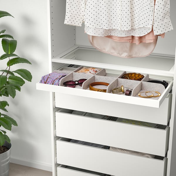 White wardrobe with pull-out tray storing accessories, keeping items organised and easily accessible.