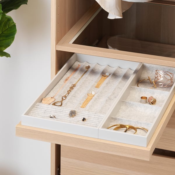 Pull-out jewellery tray with compartments for necklaces, rings, and earrings. Soft felt lining protects accessories.