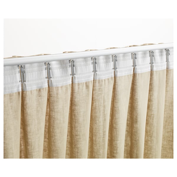 Close-up of pleated curtains with KRONILL tape, showing folds and metal hooks.