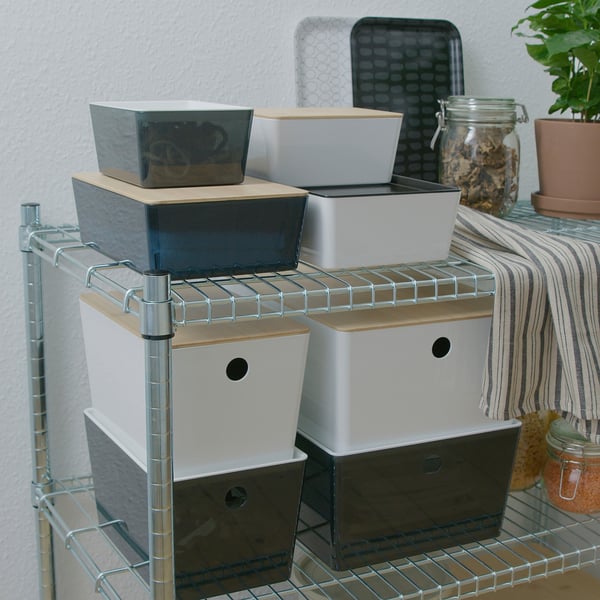 Several stacked KUGGIS boxes on shelves, sizes varying, made of bamboo and recycled pet plastic. Perfect for organising small items.