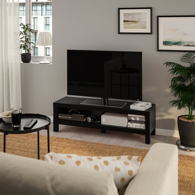 BLACK LACK tv stand fits tv perfectly, smaller than couch, holds books & plants, dark wood floor & light walls.