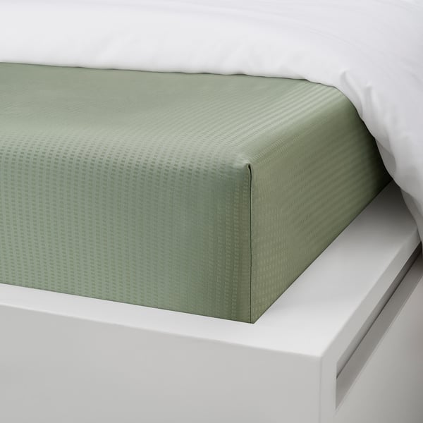 Green fitted bed sheet, elastic corners, fits mattresses up to 26 cm thick.